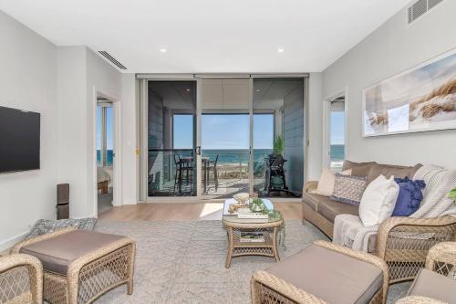 a living room with a couch and a table at Hamptons-inspired Waterfront Living on Moana Beach in Adelaide