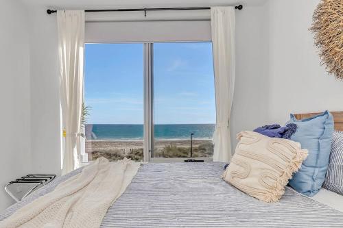 1 dormitorio con 1 cama y vistas al océano en Hamptons-inspired Waterfront Living on Moana Beach, en Moana