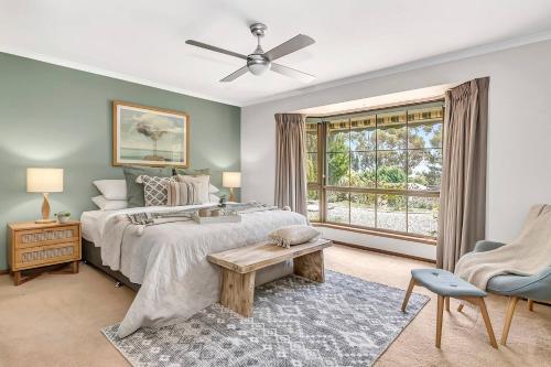 a bedroom with a large bed and a window at 'Golden Homestead' A Panoramic Vineyard Escape in McLaren Vale