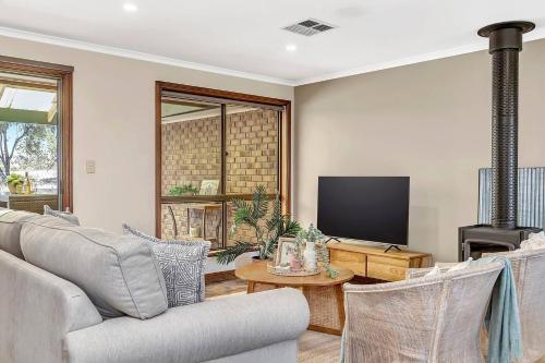 a living room with a couch and a tv at 'Golden Homestead' A Panoramic Vineyard Escape in McLaren Vale