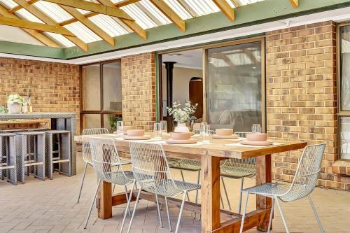 a wooden table and chairs on a patio at 'Golden Homestead' A Panoramic Vineyard Escape in McLaren Vale