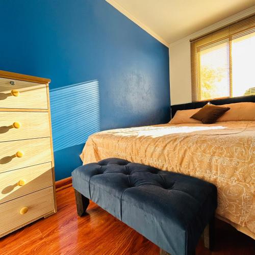 1 dormitorio con 1 cama, vestidor y pared azul en LUXURY STAY, en Santiago