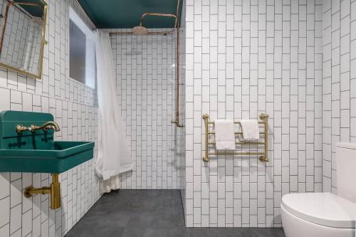a bathroom with a green sink and a toilet at Fitzroy Thrills in MacRobertson Factory Conversion in Melbourne