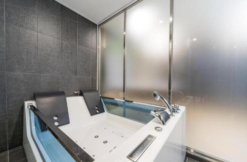 a bathroom with a bath tub with a sink at Hotel Harbor in Tongyeong