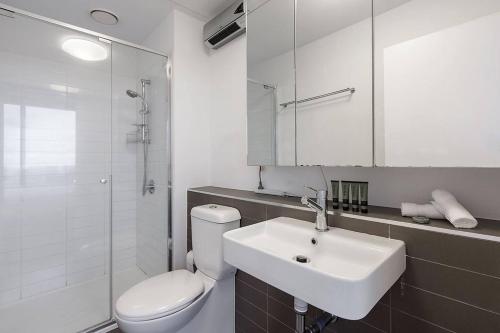 ein weißes Bad mit einem Waschbecken und einem WC in der Unterkunft Skyline Panorama in Melbourne CBD with Parking in Melbourne