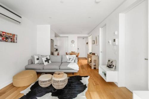 een woonkamer met een bank en een tafel bij Elster's Edge - A Stylish Elwood Escape with Terrace in Melbourne