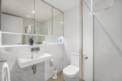a white bathroom with a sink and a toilet at Elster's Edge - A Stylish Elwood Escape with Terrace in Melbourne
