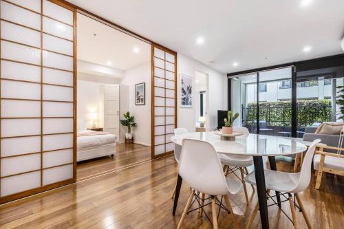 a dining room and living room with a table and chairs at Nottville Poolside - Coastal Cosmopolitan off Bay St in Melbourne