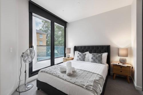 una camera con un grande letto e una grande finestra di Executive Resort-Style Living at Leafy Albert Park a Melbourne
