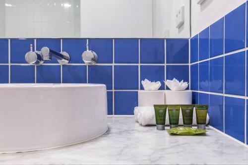 a blue tiled kitchen with a white sink and a counter at Nottville Poolside - Coastal Cosmopolitan off Bay St in Melbourne