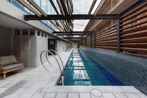 a swimming pool with a chair next to a building at Lakeside Lookout - Modern Living with Majestic Views in Melbourne