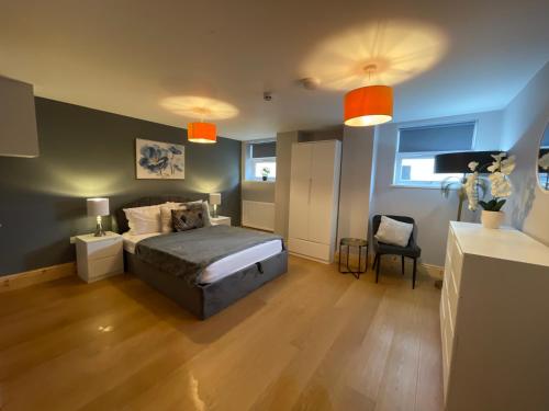West Midlands-2 Double Bed Room Apartment في دادلي: غرفة نوم فيها سرير وكرسي