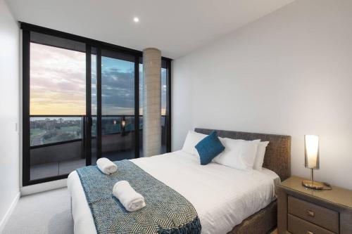 a bedroom with a bed and a large window at Lakeside Five Star Luxury with Uninterrupted Views in Melbourne