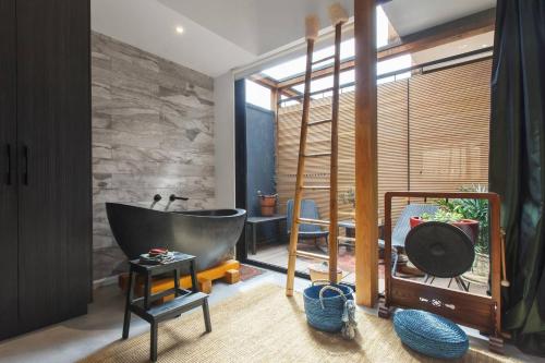 a bathroom with a tub and a stone wall at Zen State of Mind - Calming Richmond Retreat in Melbourne