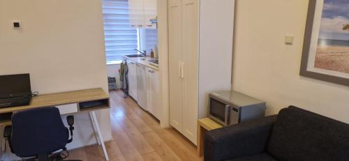 ein Wohnzimmer mit einem Sofa und einem Schreibtisch mit einem TV in der Unterkunft Apartment next to Noorderplantsoen in Groningen