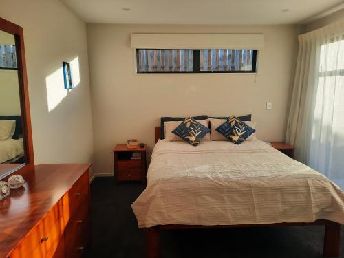 um quarto com uma cama com uma cómoda e um espelho em Colour on Cairnmuir em Wanaka