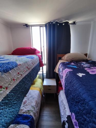 1 dormitorio con 2 camas y ventana en Departamento de 2 dormitorios y 1 baño en Arica