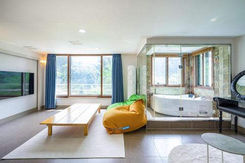 Die Pause Pool villa Pension في كابيونغ: غرفة معيشة مع مرآة كبيرة وحوض استحمام