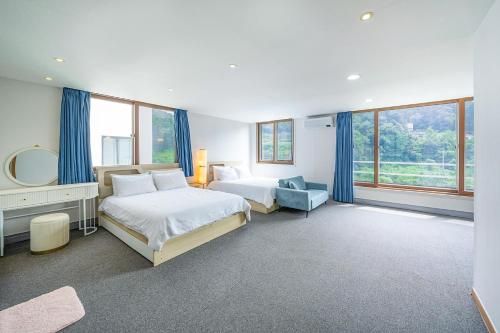 una camera d'albergo con due letti e uno specchio di Die Pause Pool villa Pension a Gapyeong