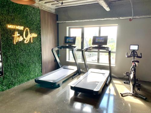 a gym with two treadmill machines and a bike at Luxury Furnished Apartment in Heart of Quincy in Quincy