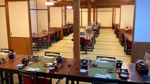 comedor con mesas y sillas de madera en Jomon no Yado Manten en Yakushima