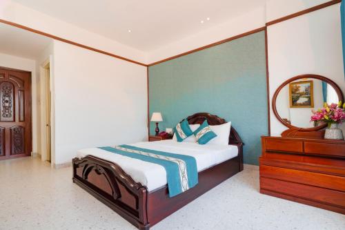 a bedroom with a bed with a mirror and a dresser at CHUONG DUONG HOTEL in My Tho