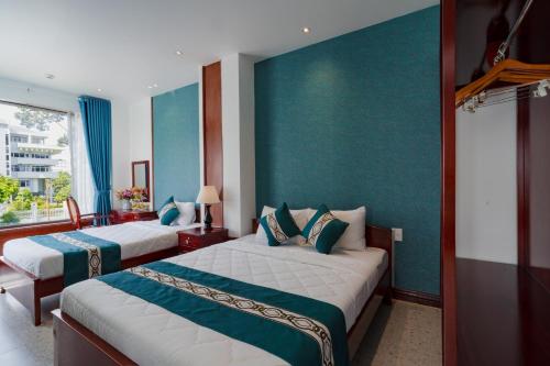 two beds in a hotel room with blue walls at CHUONG DUONG HOTEL in My Tho