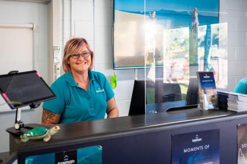 an older woman standing behind a cash counter at BIG4 Tasman Holiday Parks - Rowes Bay in Townsville