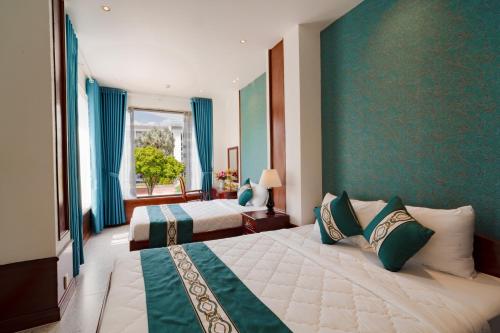 um quarto de hotel com duas camas e uma janela em CHUONG DUONG HOTEL em Mỹ Tho