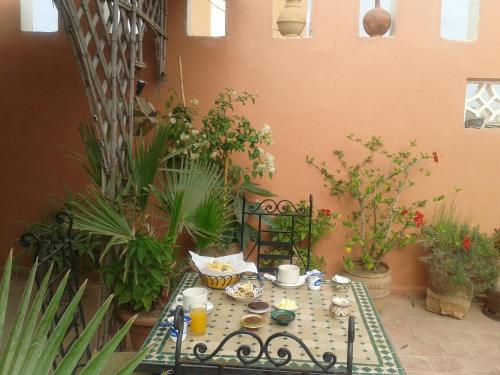 ein Tisch mit Essen darauf in einem Innenhof mit Pflanzen in der Unterkunft Chambres d'Hôtes les amis in Taroudant
