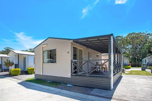 a tiny house with a deck on a driveway at Ingenia Holidays Middle Rock in One Mile