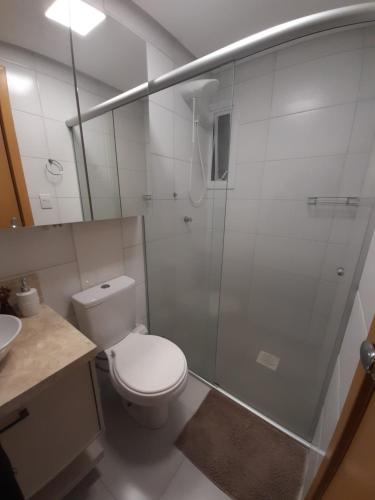 y baño con ducha, aseo y lavamanos. en Apartamento bem localizado, en Bento Gonçalves