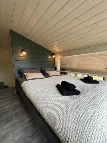 a bedroom with a large bed with a wooden ceiling at Mirest - котедж в горах із чаном-джакузі in Slavske