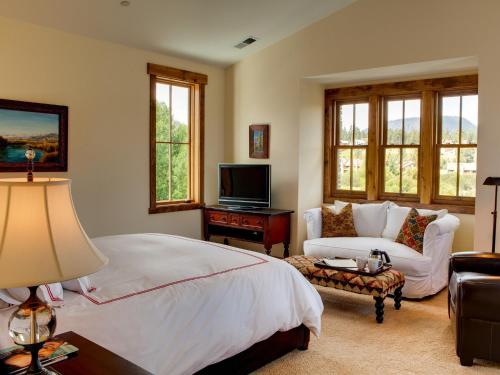 Snowcreek Resort Vacation Rentals في بحيرات ماموث: غرفة نوم بسرير واريكة وتلفزيون
