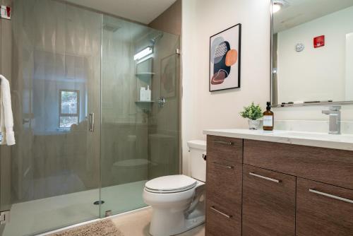 a bathroom with a shower and a toilet and a sink at Modern Furnished Apartment in Heart of Quincy in Quincy