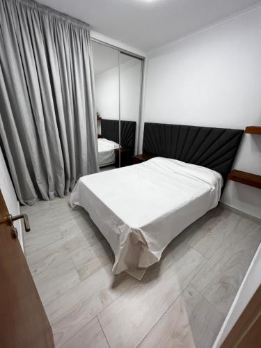 a bedroom with a white bed in a room at Casa con pileta y garaje in Roque Sáenz Peña