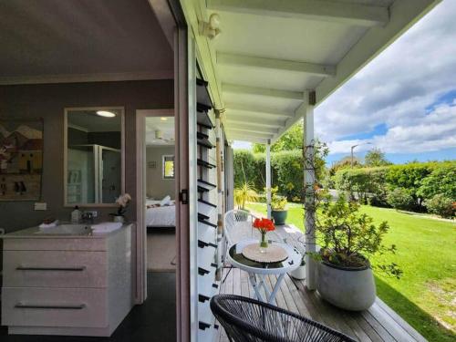 a porch with a sink and a bathroom on a deck at Hahei Getaway Tahi in Hahei