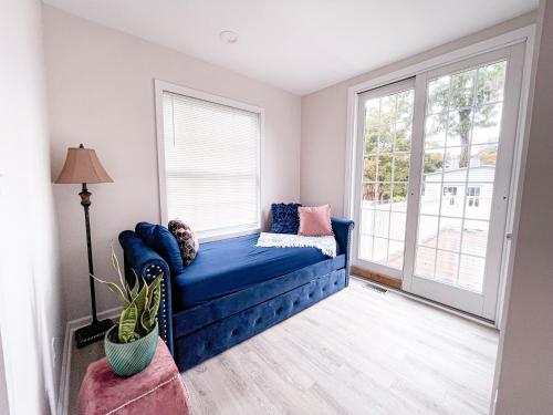 um sofá azul num quarto com uma janela em Cheerful & Modern Home w/ a Walkout Deck Area em Glenside