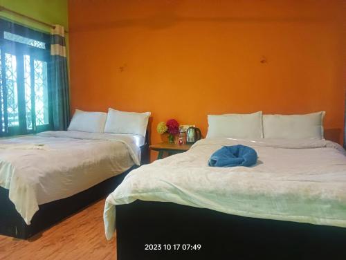 two beds sitting next to each other in a room at Hotel Butterfly - Peaceful Garden for Nature Lovers in Sauraha