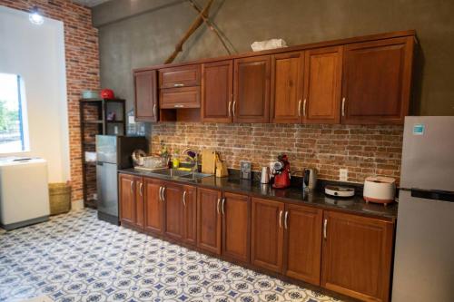 a kitchen with wooden cabinets and a refrigerator at Vungtau Surf Hostel in Vung Tau