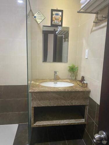 a bathroom with a sink and a mirror at Quê Tôi Hotel in Soc Trang