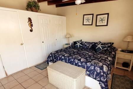 1 dormitorio con 1 cama y 1 taburete en una habitación en CASA MARBELLA 2BR 1BA Private Beach-Front Home, en Cabo Punta Banda