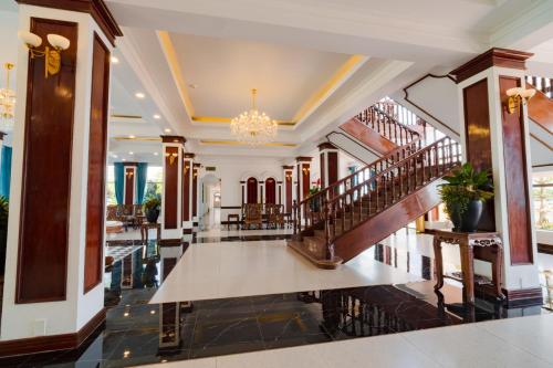 a lobby of a hotel with stairs and a chandelier at CHUONG DUONG HOTEL in My Tho