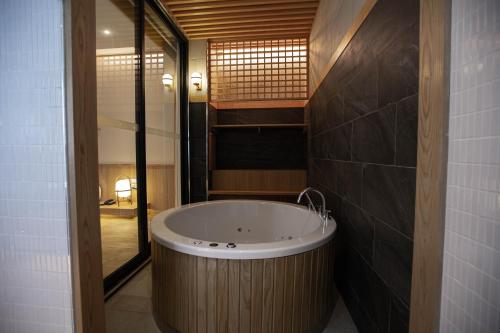 Cette chambre comprend une salle de bains pourvue d'une grande baignoire. dans l'établissement The Arch Phuket Hotel, à Ban Ket Ho