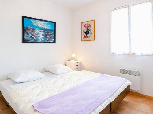 une chambre avec un grand lit blanc dans une pièce dans l'établissement T2 à Narbonne-Plage, terrasse, parking, animaux admis - FR-1-409-166, à Narbonne