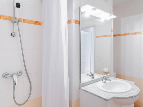 une salle de bain blanche avec un lavabo et une douche dans l'établissement T2 à Narbonne-Plage, terrasse, parking, animaux admis - FR-1-409-166, à Narbonne