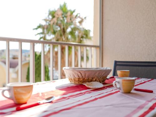une table avec deux tasses et un bol en dessus dans l'établissement Appartement T3 climatisé, rénové, 3 étoiles, avec parking privé et proche du port de Gruissan - FR-1-409-164, à Gruissan