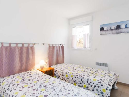 une chambre avec deux lits et une fenêtre dans l'établissement Charmant T3 à 300m de la plage, Balcons, Parking, Proche Commerces, Narbonne-Plage - FR-1-409-169, à Narbonne
