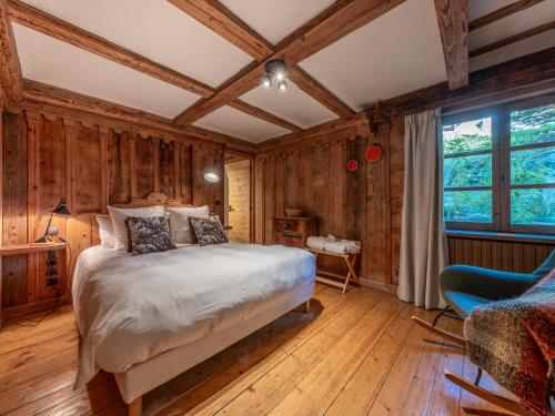 - une chambre avec des murs en bois, un lit et une fenêtre dans l'établissement Chalet familial authentique avec spa, jacuzzi et hammam - Courchevel 1850 - FR-1-613A-26, à Courchevel