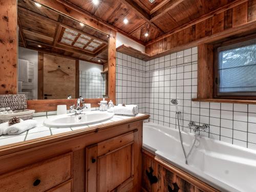 une salle de bain avec une baignoire et un lavabo dans l'établissement Chalet familial authentique avec spa, jacuzzi et hammam - Courchevel 1850 - FR-1-613A-26, à Courchevel